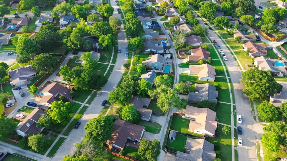 A roofer surveying a neighborhood from a rooftop, representing the competitive roofing market